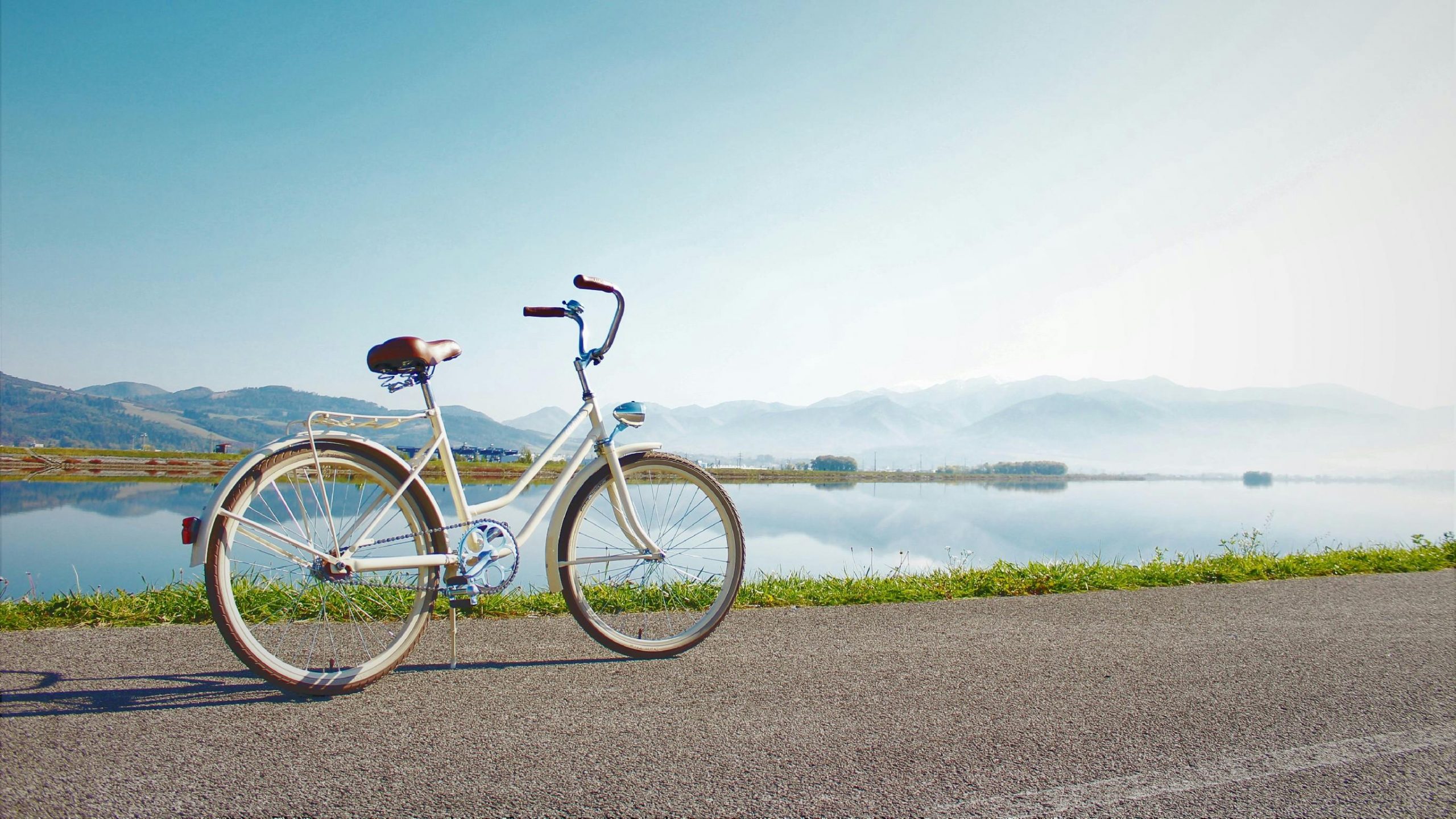 Geparkeerde fiets in een bergachtig landschap aan een meer